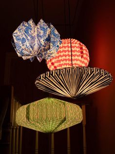 three colorful paper fans hanging from the ceiling