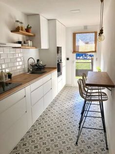 a kitchen with white cabinets and tiled flooring