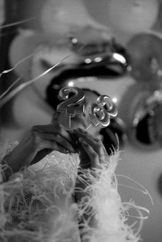 black and white photograph of a woman's hands holding a glass ball with numbers on it