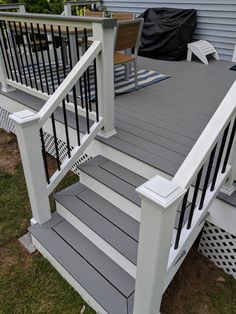 a deck with steps and railings in front of a house