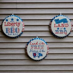 three red, white and blue bottle caps hanging from the side of a building with liberty for all written on them