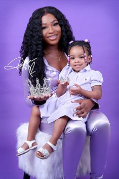 a woman holding a small child wearing a tiara and sitting on her lap,