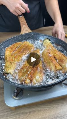 someone cooking food in a skillet on top of a stove