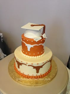 a three tiered cake with white and orange frosting