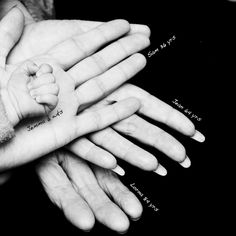 several hands are stacked together holding a baby's hand with words written on it