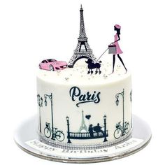 a cake decorated with the eiffel tower and pink car is on a plate