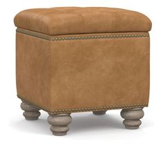 a brown foot stool with studding on the legs and an ottoman cushion in front of it