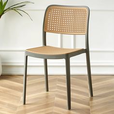 a chair sitting on top of a hard wood floor next to a potted plant