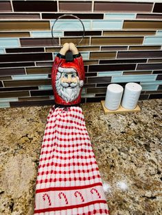 a red and white checkered towel with a santa claus face on it sitting on a counter