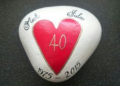 a white and red heart shaped rock with the number 40 on it's side