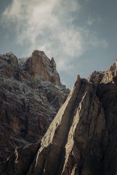 the mountains are covered in snow and there is a bird flying above them on a sunny day