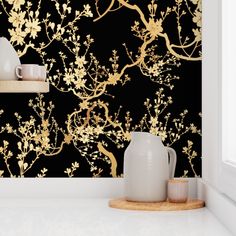 the wallpaper is black and gold with white flowers on it, along with two vases