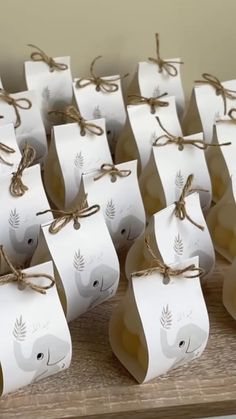 small white bags with brown string tied around them on a wooden counter top, each containing an elephant's head