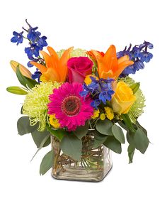 a vase filled with colorful flowers and greenery