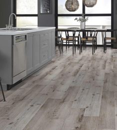 a kitchen with grey cabinets and wood floors