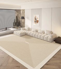 a living room with a large white couch and rug on top of the wooden floor