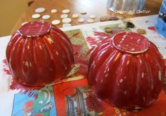 two red vases sitting on top of a table next to coins and other items