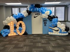 the balloon arch is decorated with blue, white and black balloons that spell out 10