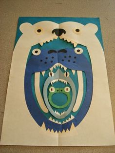 a paper cut out of a polar bear with an animal's face on it