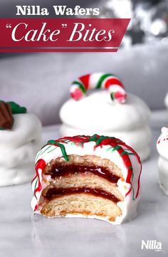 some white cakes with red and green icing on top of each other, one has a bite taken out of it