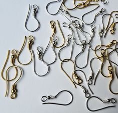 many different types of metal clips and hooks on a white surface with clippings attached to them