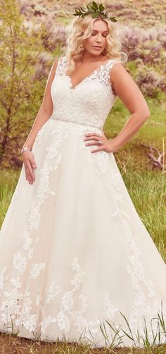 a woman in a wedding dress posing for the camera with her hands on her hips