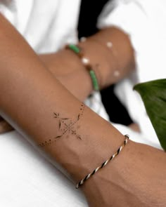 a woman's arm with a small star tattoo on it