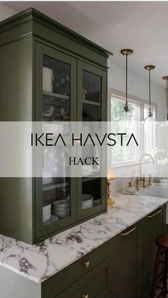 a kitchen with green cabinets and marble counter tops in front of a window that reads ikea havsta hack