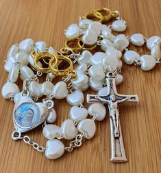 "Personalized rosary with white hearts beads for wedding. Wedding rosary with a name for newlyweds. If you want to brighten up someone's wedding day and give them a personal gift, you can order a wedding rosary with a name. This beautiful rosary it's perfect gift for wedding. In every part of Our Father is two rings what symbolizes weddings. Its made with medal Virgin Mary and cross MIR, MIR, MIR ( PEACE, PEACE, PEACE). You can order: 1.only rosary 2.rosary with one name(only bride or only groom Wedding Spiritual Cross Rosary, White Spiritual Rosary For Anniversary, Personalized Rosary With Round Beads For Wedding, Personalized Wedding Rosary With Round Beads, White Rosary, Wedding Rosary, Wedding Hearts, St Benedict Bracelet, Beautiful Rosary