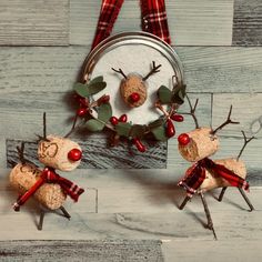 three reindeer ornaments are hanging on the wall next to a basket with holly and berries