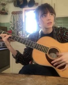 a young man is playing an acoustic guitar