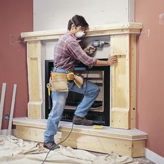 a man working on a fireplace with a power drill