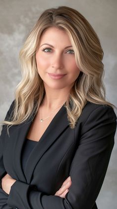 a woman in a black suit with her arms crossed