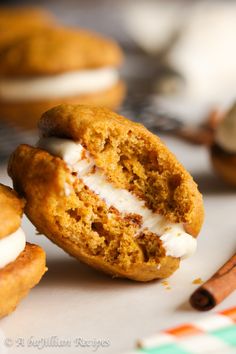 two cookies with white frosting and cinnamon sticks next to them on a counter top