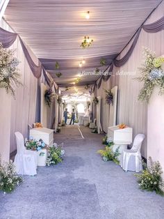 an aisle decorated with white chairs and flowers