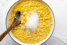 a wooden spoon in a pot filled with corn