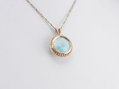 Larimar is called the sea stone, and this gorgeous pendant provides an excellent example of why! The rope-twist framework of yellow gold brings warmth and richness to the larimar, pulling the waves of seafoam green forward and swirling them with the other shades. This pendant does not come with the chain shown. Please feel free to contact us, we will help you find the perfect chain for your style and budget! Metal: 14K Yellow Gold Gem: Larimar Gem Measurements: 12.0 mm, Round Measurements: 17 x Elegant Larimar Cabochon Jewelry, Hallmarked Larimar Jewelry, Elegant Round Larimar Jewelry, Elegant Larimar Pendant Jewelry, Larimar Gemstone Necklace For Anniversary, Elegant Larimar Jewelry For Formal Events, Anniversary Larimar Gemstone Necklace, Vintage Gold Pendant, Blue Stone Pendant