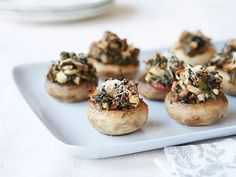 small stuffed mushrooms with toppings on a white plate