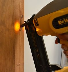 a person using a power drill to attach a piece of wood with screwdrivers