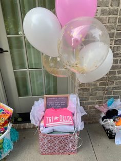 balloons, cake and other items are on display outside the front door of a house