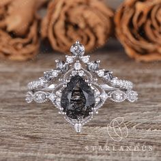 a black and white diamond ring sitting on top of a wooden table