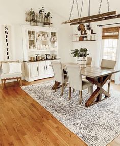 a dining room table with chairs and a rug on the floor