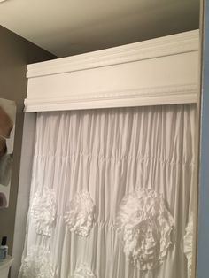 a white curtain with ruffles hanging from it's side