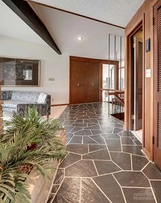 the entry way to a large house with stone flooring and wood trimmings