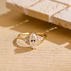 a diamond ring sitting on top of a wooden table next to a piece of wood