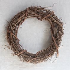 a close up of a wreath made out of twigs on a white surface with no one around it