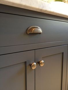 an image of a gray cabinet with brass knobs