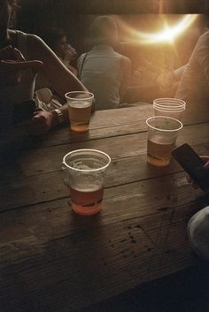 several people sitting at a table with cups on it