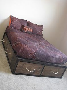 a bed with two drawers underneath it in a room