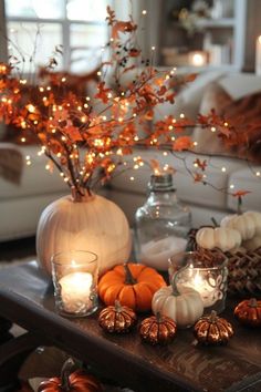 a living room filled with lots of pumpkins and candles on top of a table